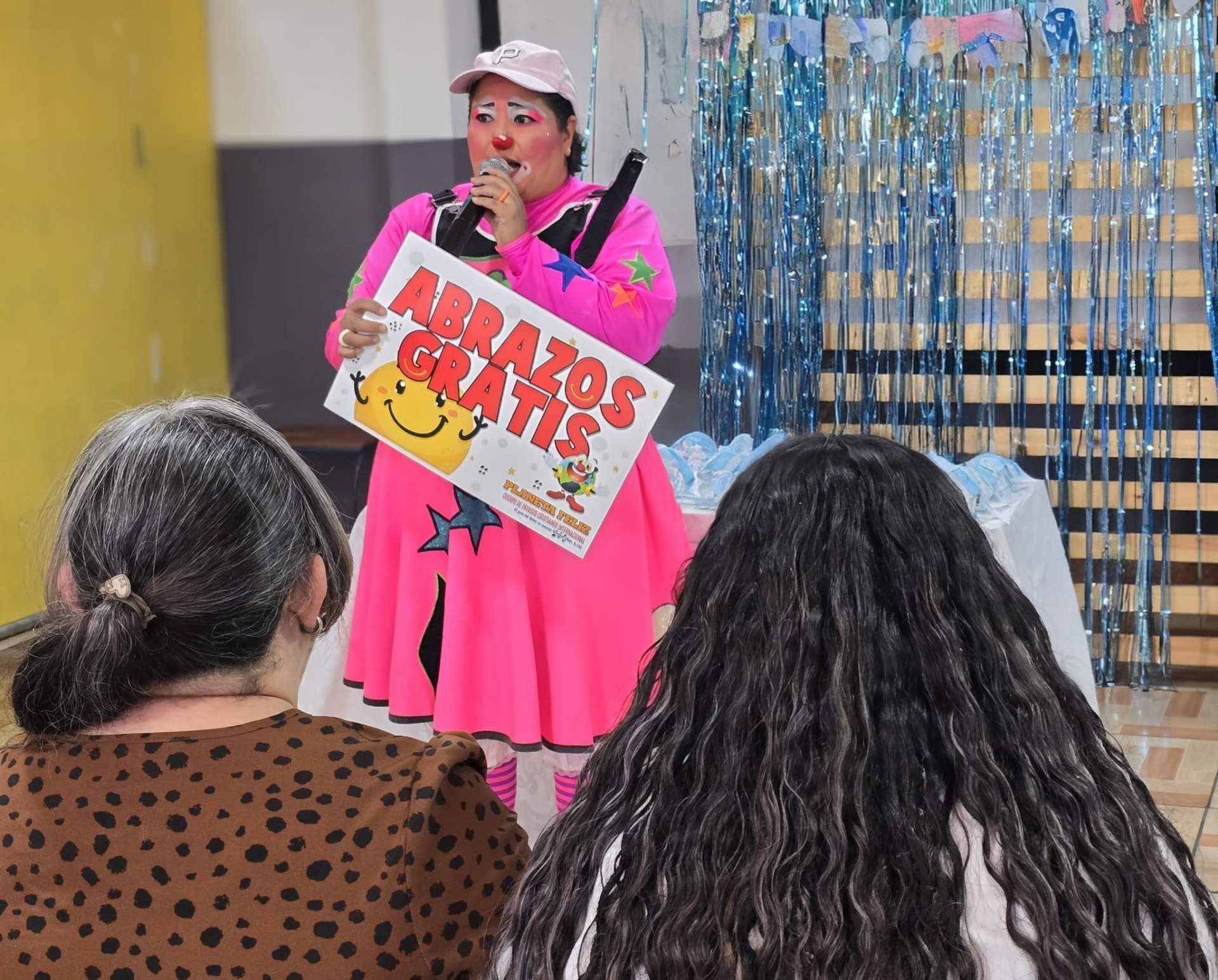 Payasa de PayaSOS 33.3 con el cartel Abrazos Gratis en El Salvador